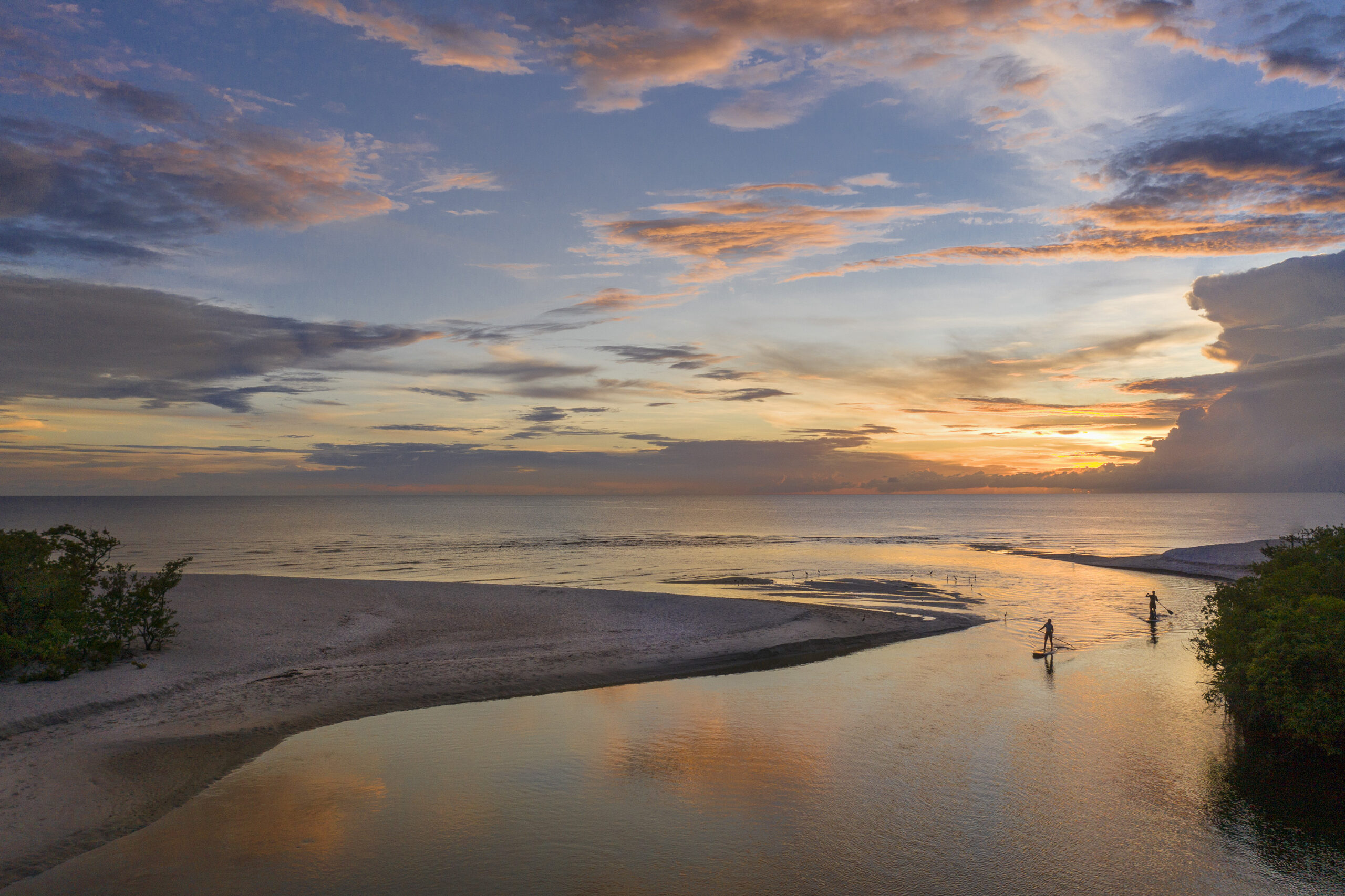 A couple make their way through Clam Pass against the backdrop of another beautiful Gulf sunset. Photo by Ed Chappell.